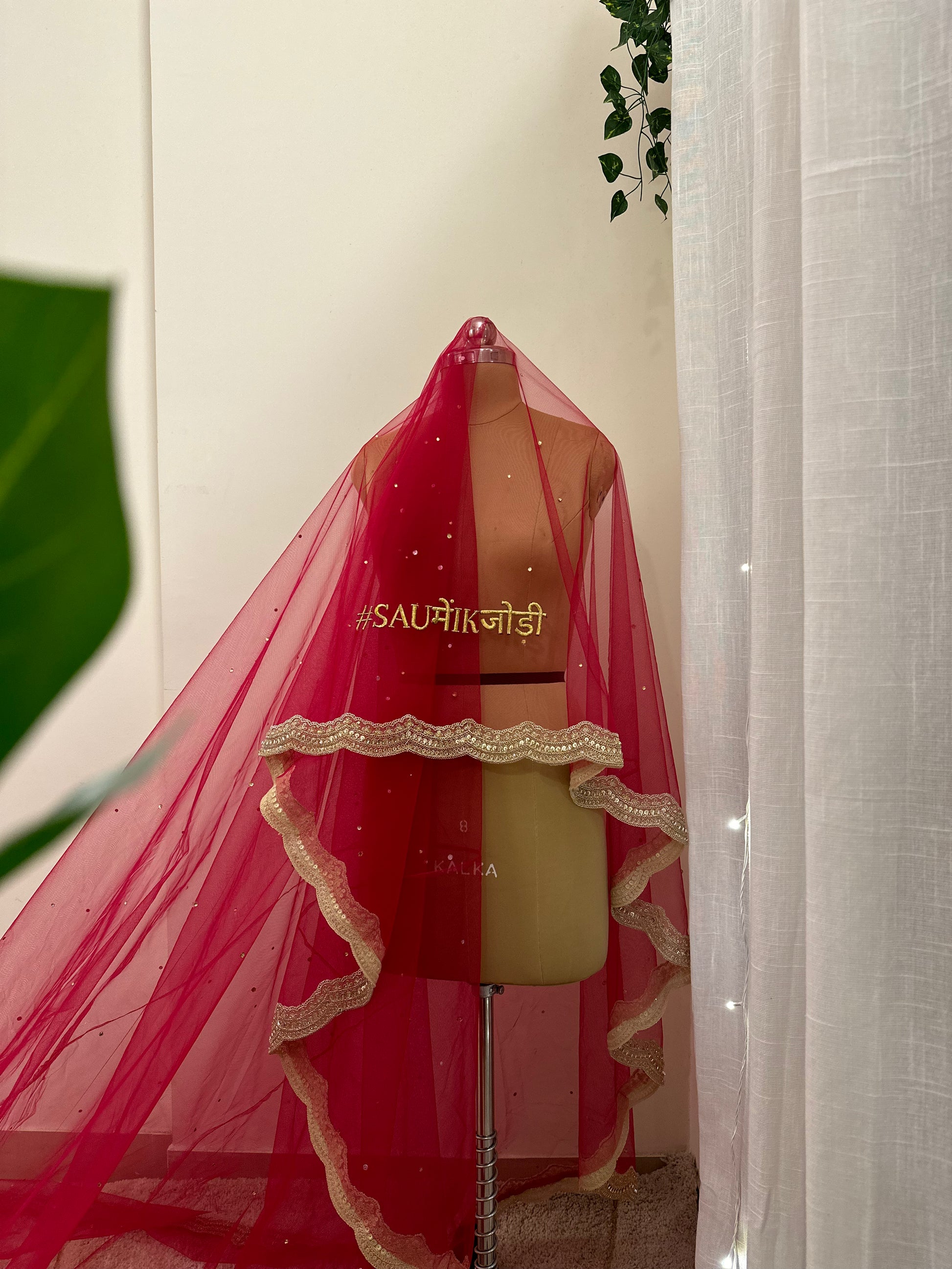 rani pink saree with gold border on a mannequin against a neutral background
